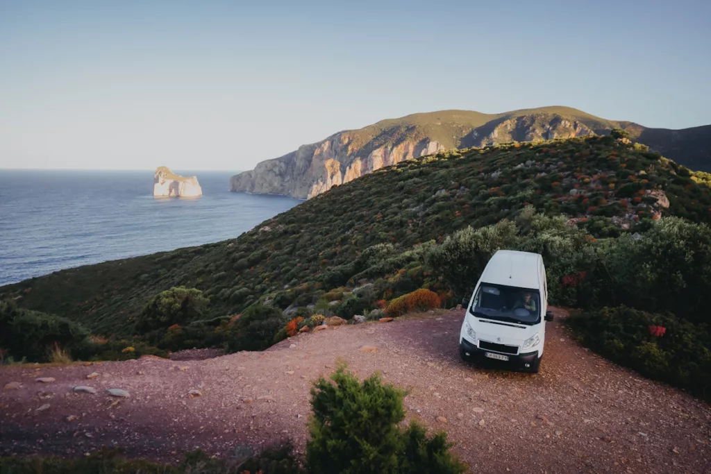 Spot de van à Masua avec vue sur la mer et les falaises de Porto Flavia.