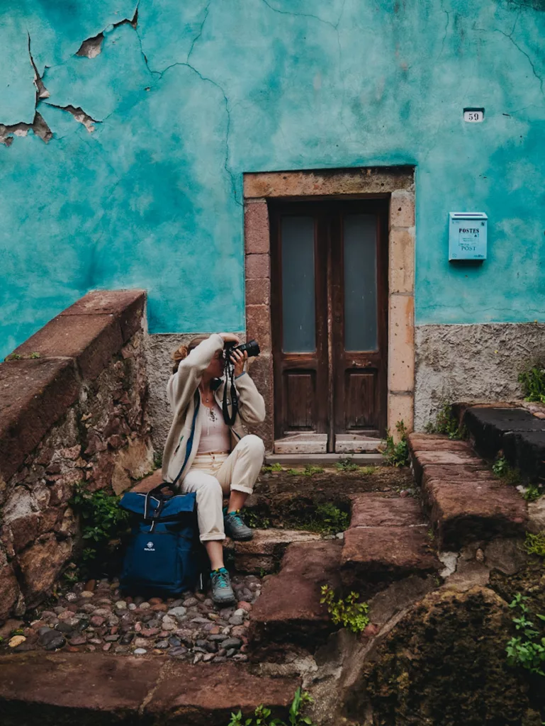 Maison bleue et femme qui prend une photo dans la ville de Bosa en Sardaigne.