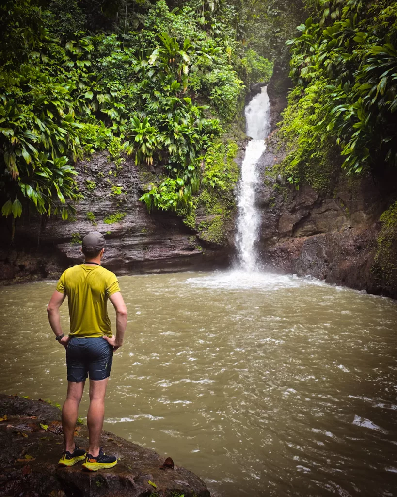 Randonnée en Guadeloupe : randonneur devant une cascade dans la Ravine Tambour.
