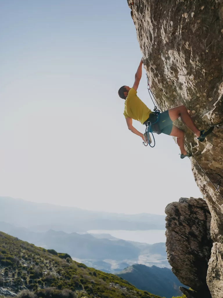 Grimpeur dans une voie en 6b sur la falaise du Pignu (secteur des Antennes) en haute-Corse proche de Bastia et Saint-Florent.