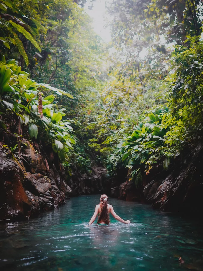 Randonneuse dans l’eau, au cœur du canyon étroit de la rivière Moustique, en pleine forêt de Basse-Terre.

