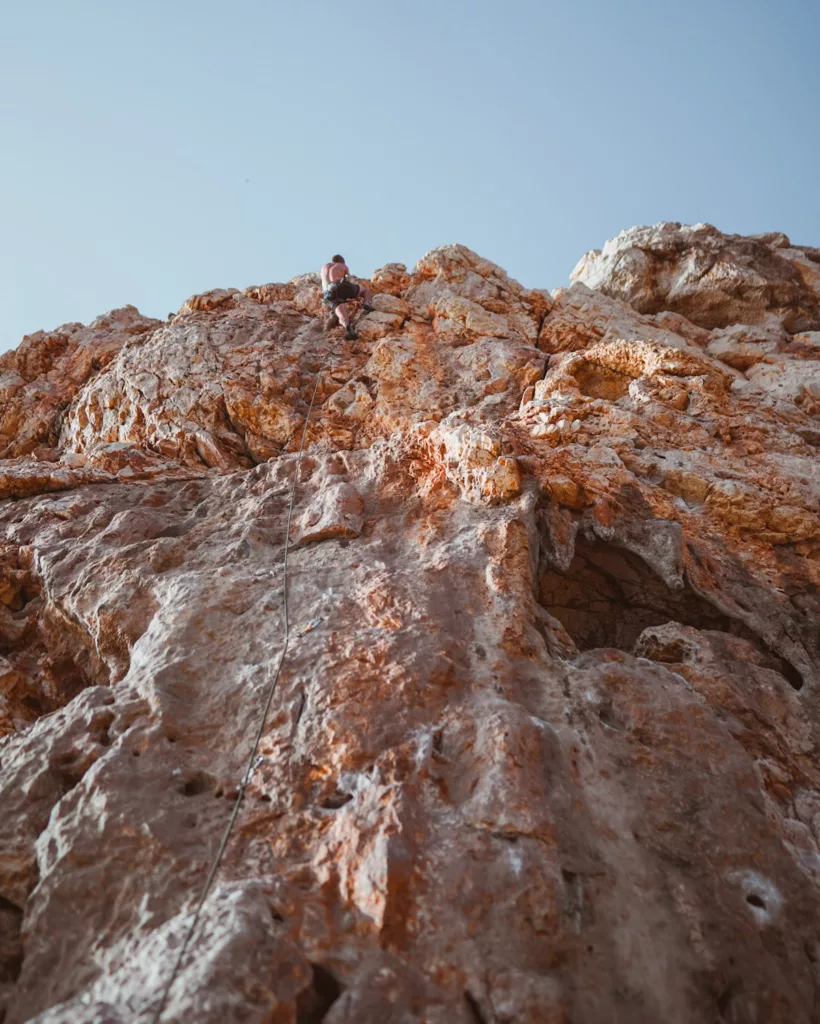 Grimpeur dans une voie de la falaise d'escalade de Casarotto à Capo caccia.