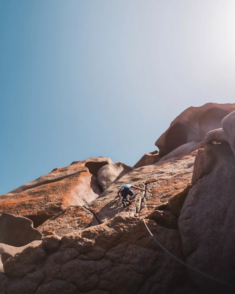 Grimpeur sur la dale à friction de Capo Testa (escalade).