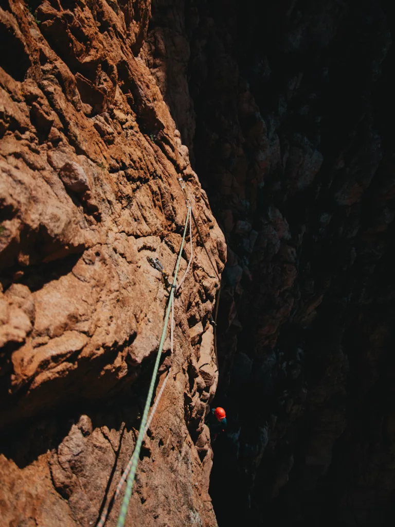 Ombre et lumière sur la falaise de l'Ambata di Melu à Porto en Corse, grimpeuse dans une grande voie en Corse.