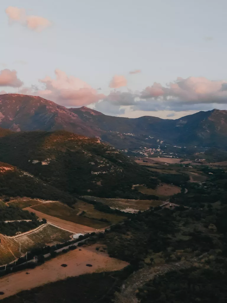 Le village de Patrimonio et les montagnes au coucher du soleil. Vue sur les vignobles.