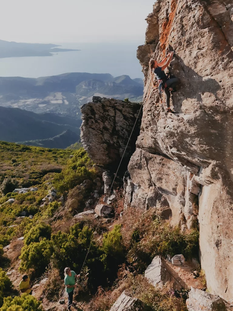 Grimpeuse dans une voie en 6b au secteur des Antennes sur la falaise du Pignu en Corse.