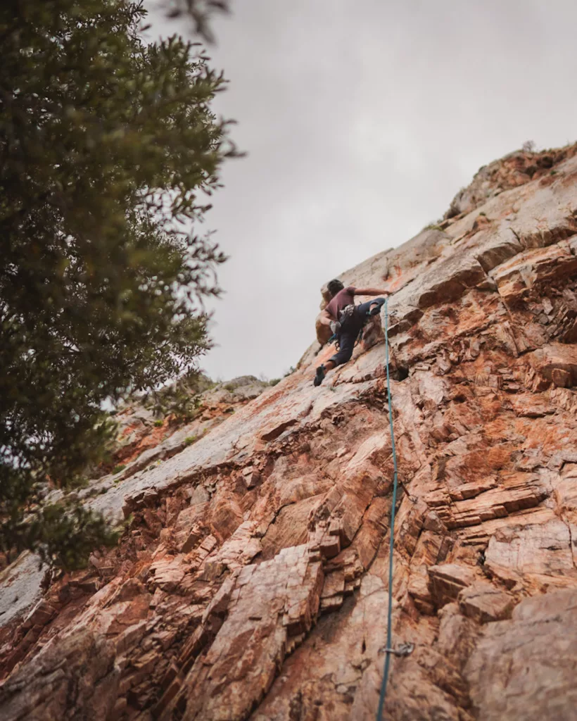 Grimpeur sur la falaise calcaire d'escalade structurée de Masua en Sardaigne.