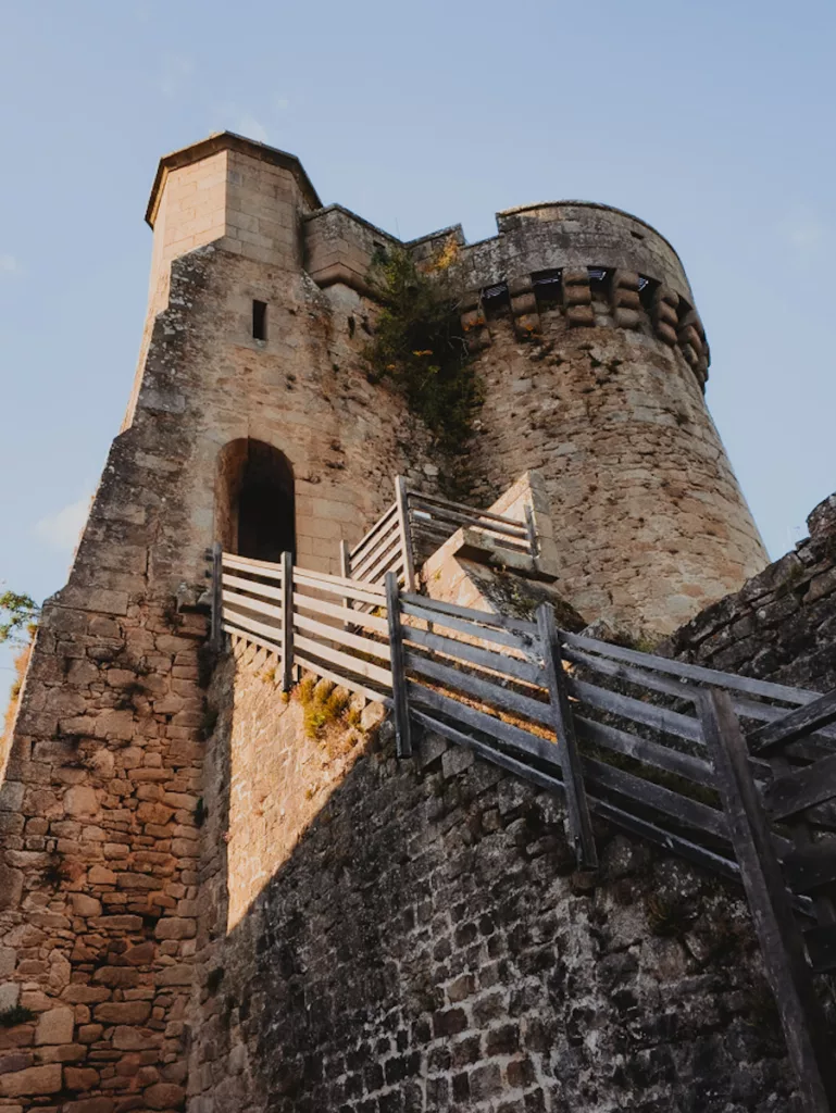 Vue en contre-plongée de la Tour Saint-Jacques lors d’une visite de la cité médiévale de Parthenay, mettant en valeur l’imposante architecture fortifiée et les pierres anciennes.