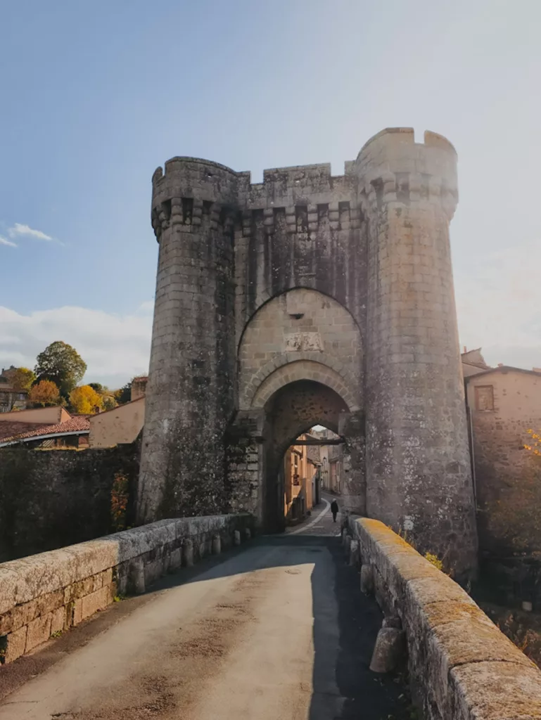Vue de la Tour Saint-Jacques depuis le pont Saint-Jacques lors d’une visite de la cité médiévale de Parthenay, avec les remparts et la rivière Thouet en arrière-plan.