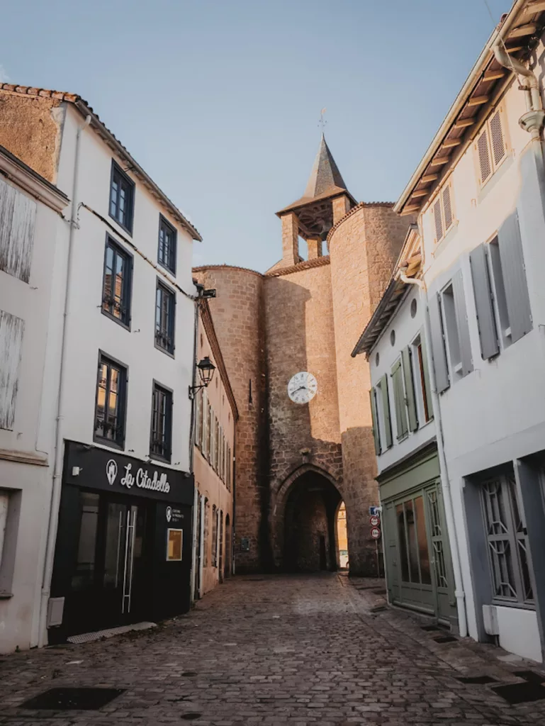 La Porte de l’Horloge, emblème de la cité médiévale de Parthenay, photographiée lors d’une visite, avec sa tour et son horloge qui surplombent la rue pavée.