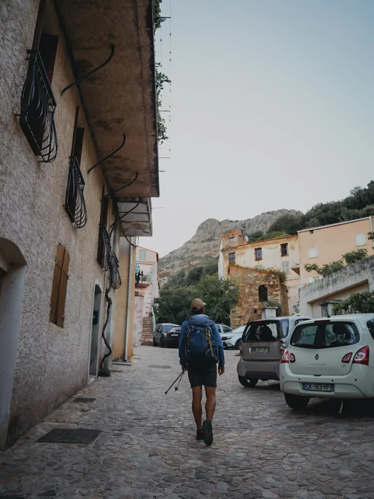 départ  de Calenzana pour faire le GR20 en Corse en automne, homme qui marche dans la rue au départ du GR20.