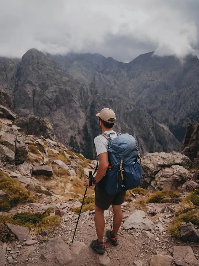 Randonneur façe aux montagnes du GR20 à un col.