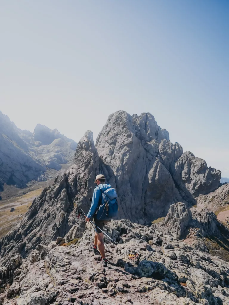 Homme qui marche sur un sentier en crête sur l'ancien tracé du GR20 avant le cirque de la Solitude.