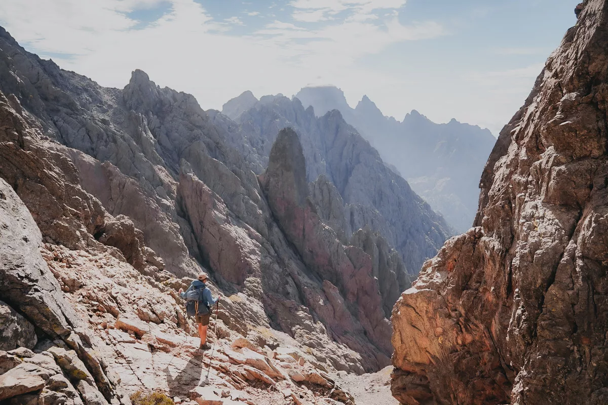 Randonneur contemplant les paysages du Cirque de la Solitude en Corse, passage très dangereux du GR20.