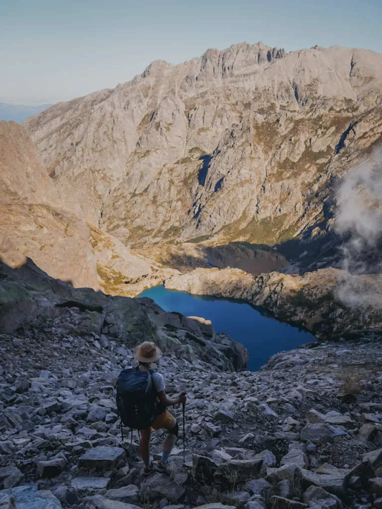 Randonneuse face aux lacs de Melo et Capitello, deux des plus beaux lacs de Corse sur le GR20.