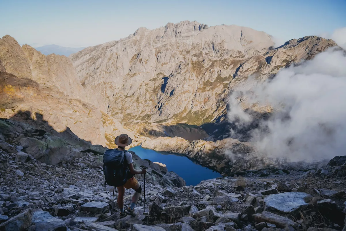 Randonneuse face aux lac de Melo et Capitello en Haute Corse, partie nord du GR20 en automne, quel matériel de trek pour faire le GR20.