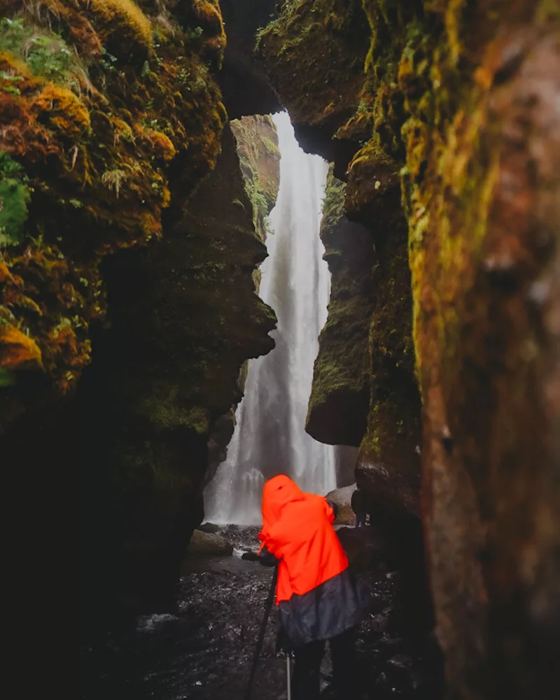 Photographe devant la cascade de Gljúfrabúi dans le sud de l'Islande proche de Seljalandsfoss.