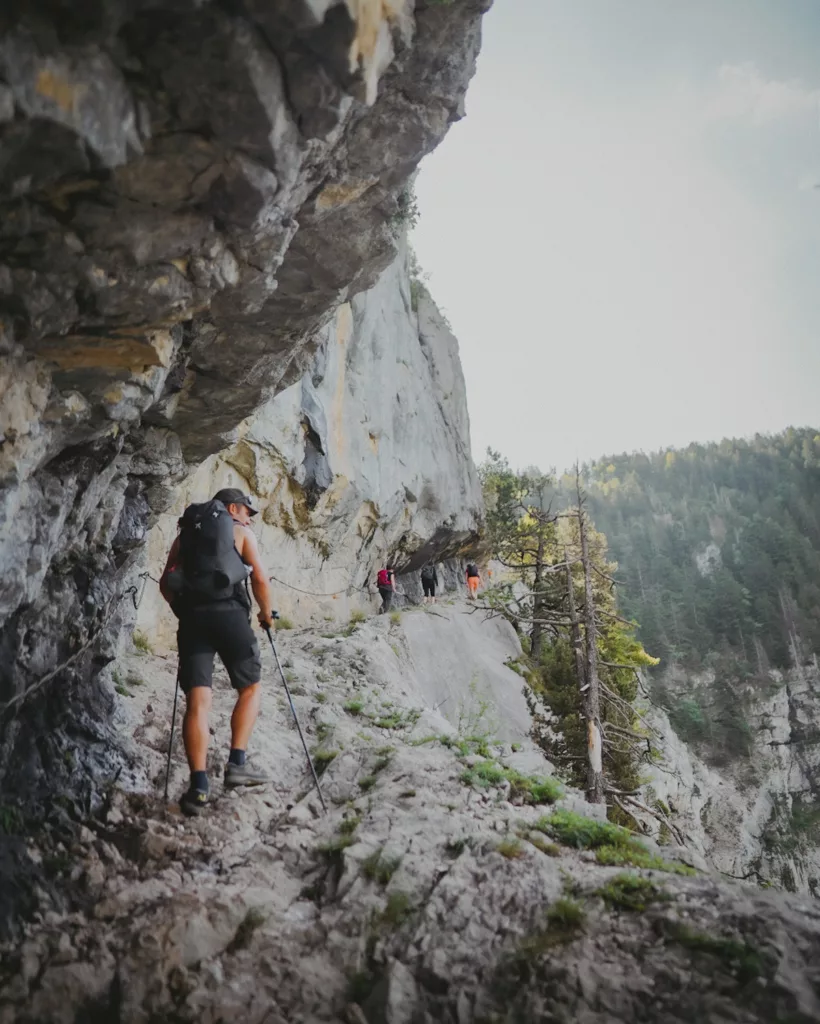 Randonneur montant au pas du roc, un chemin sculpté dans le roche en Haute-Savoie proche d'Annecy.