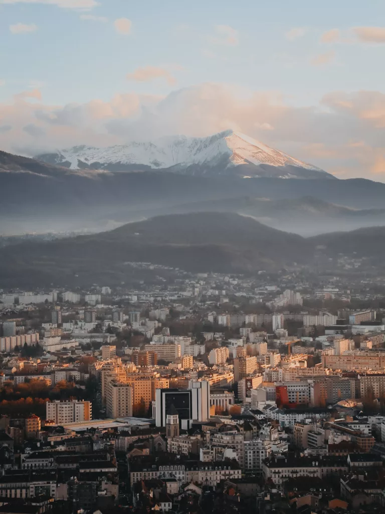 Vue sur Grenoble au coucher du soleil en Isère en hiver depuis la via ferrata de Grenoble.