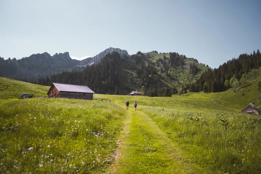Randonneurs devant les chalets de Petetoz à proximité de la Pointe de Chalune, itinéraire de randonnée en Haute-Savoie dans le massif du Chablais.