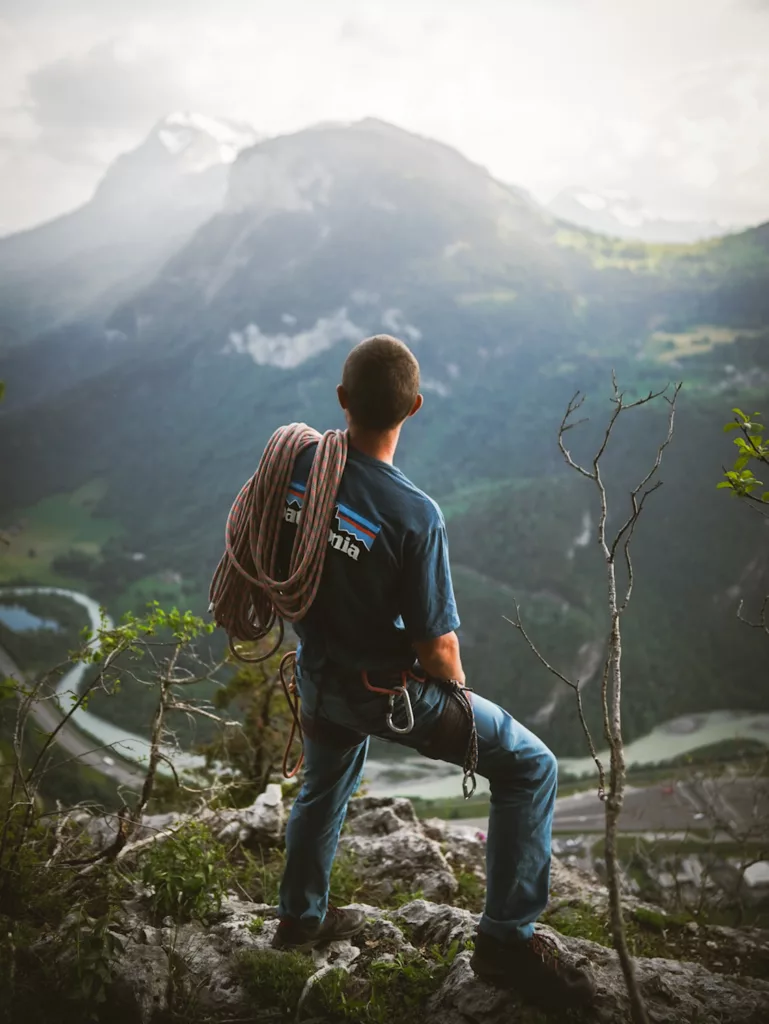Grimpeur habillé en Patagonia face à la vallée de l'Arve en haut de la falaise de la Maladière en Haute-Savoie, recommandations escalade dans les Alpes.