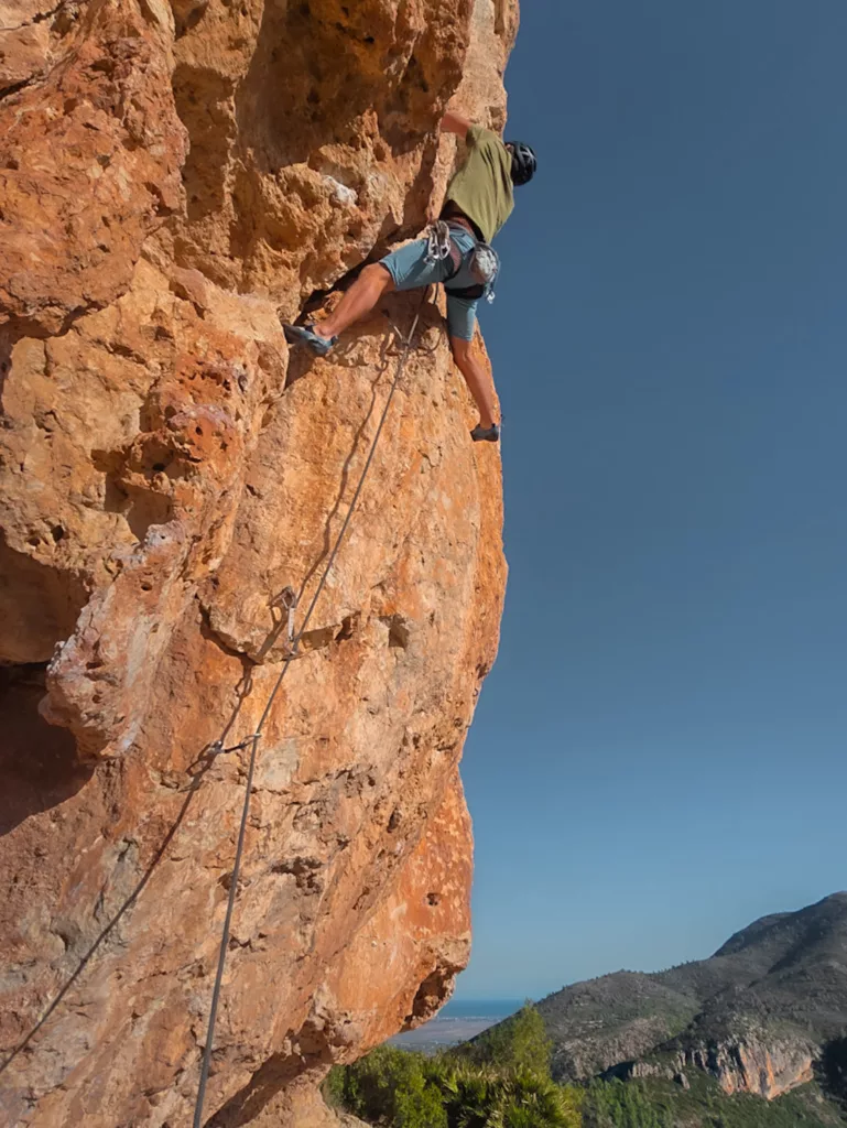 Grimpeur sur le rocher orange de Tallat Roig en Espagne. Grimper dans la communauté de Valence.