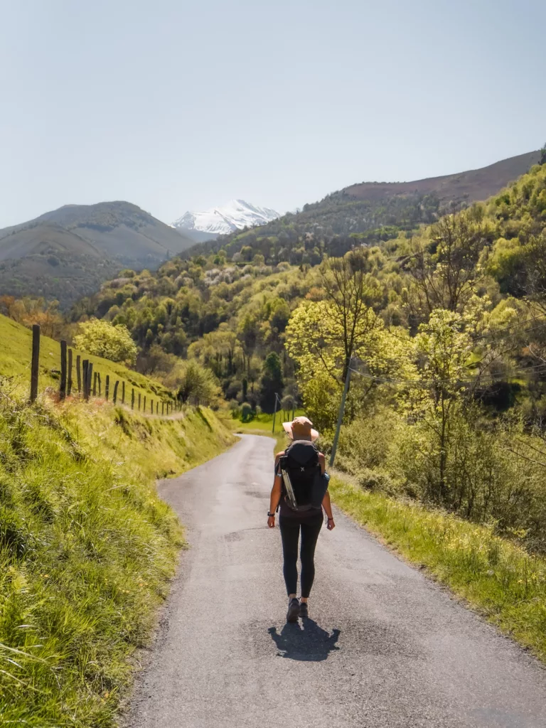 Randonneuse sur une petite route de campagne dans les Pyrénées au printemps proche de Lourdes.