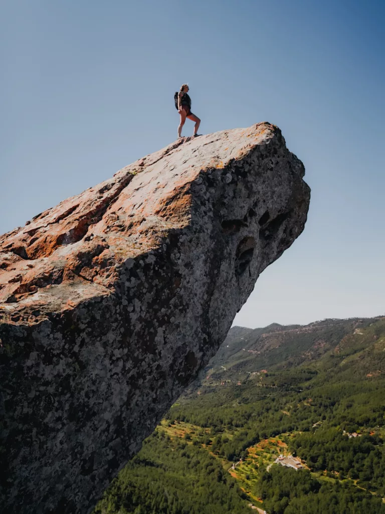 Randonnée atypique au Trampolí del Diable dans la région de Valence proche de Benicàssim.  Femme au bout d'un rocher au dessus du vide en Espagne.