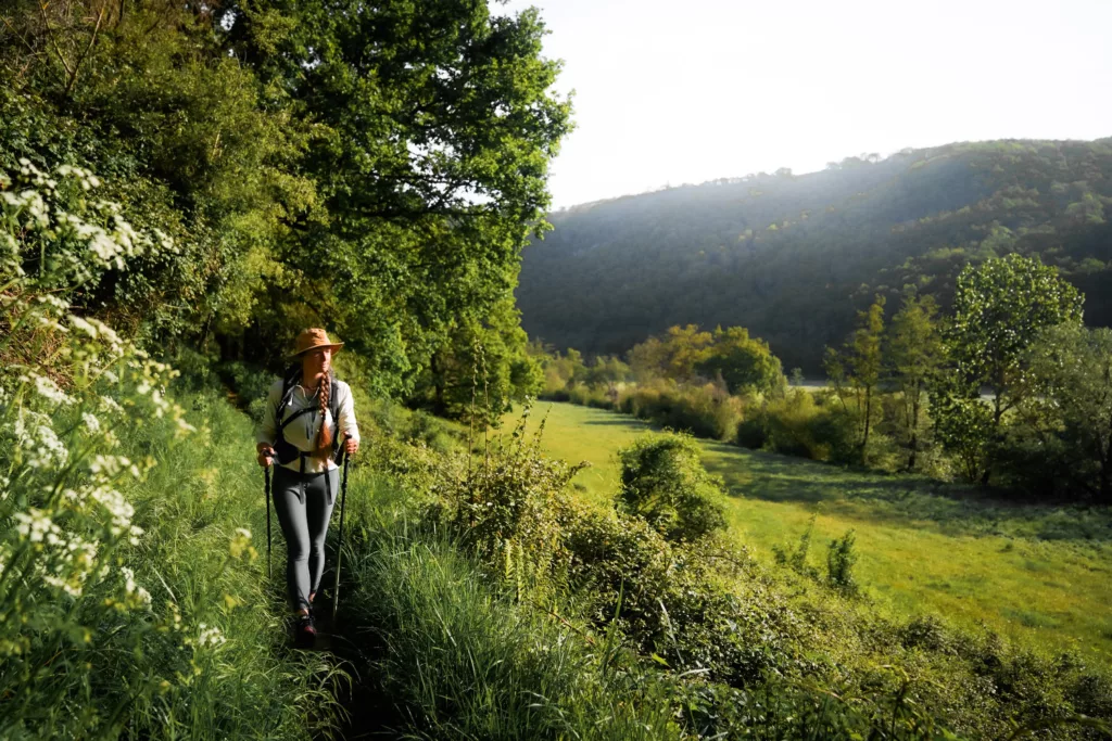 Randonnée en Normandie : le plus belle randonnée de Suisse Normande à Clécy. Randonneuse dans la verdure au bord de l'OIse en Suisse Normande.