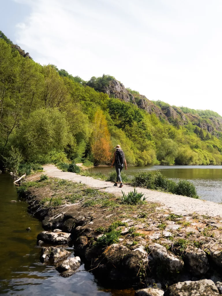 Randonnée en Normandie : le plus belle randonnée de Suisse Normande à Clécy. Randonneuse qui traverse l'Oise en dessous du viaduc de Clécy.