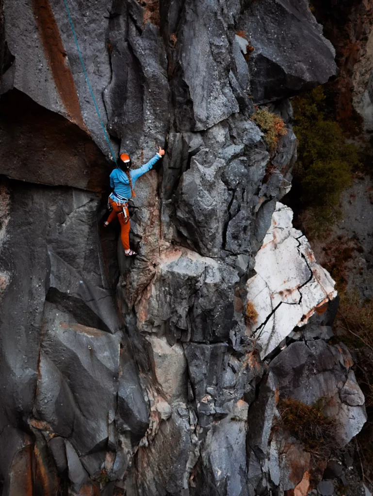 Grimper à Martigny : site d'escalade de Dorénaz, secteur Arête des comiques et Dalle du Vaudois. Grimpeuse dans la voie Khaled.