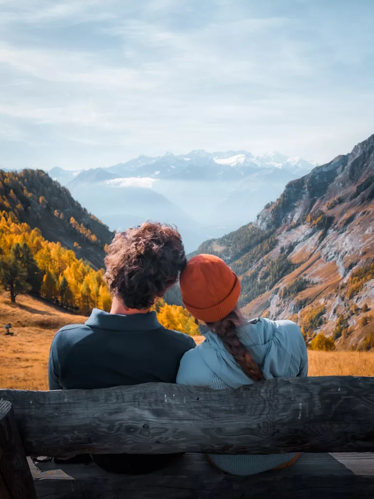 Couple de randonneurs face aux montagnes avec les belles couleurs d'automne dans la région de Martigny dans le Valais en Suisse.